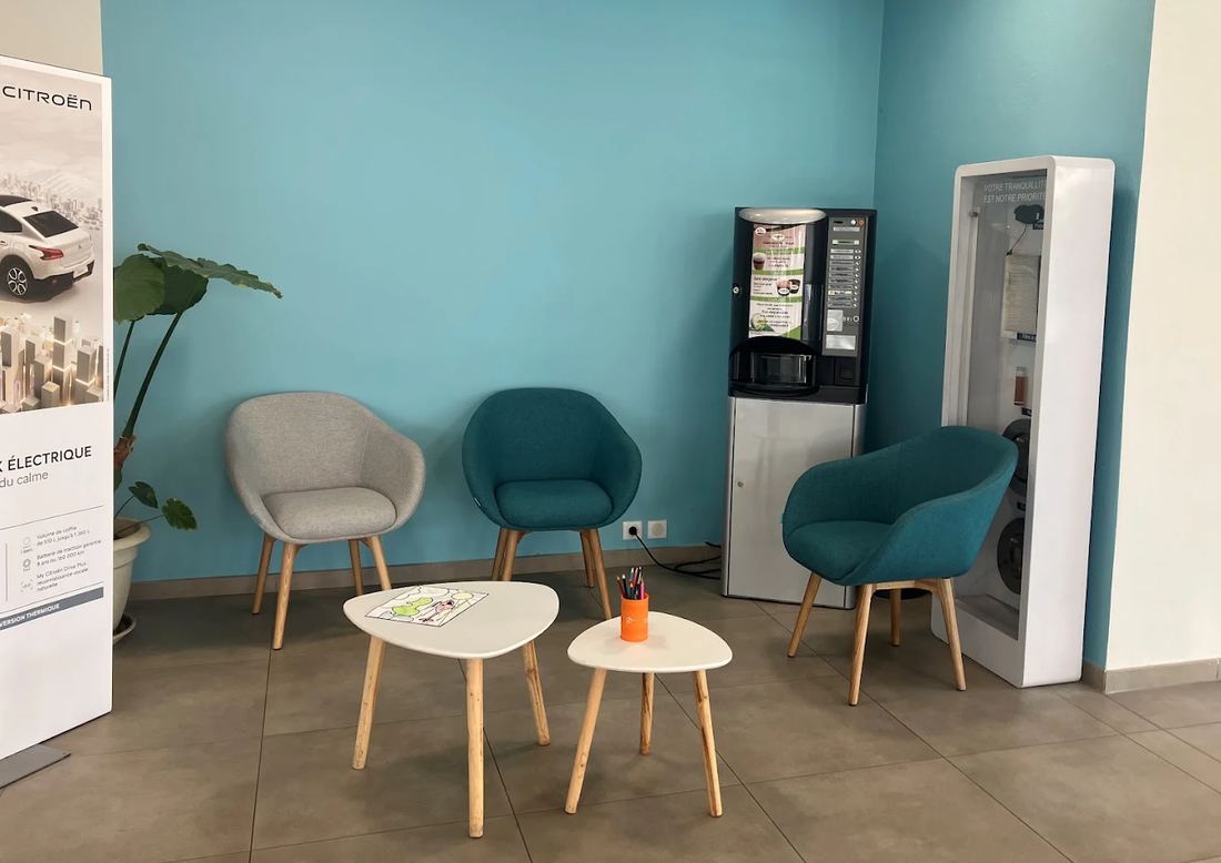 Espace d'attente avec fauteuils, machine à café et coin coloriage
